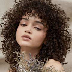 Tea Tree Lavender Mint Conditioning Leave-In Spray being applied for smoother, frizz control.