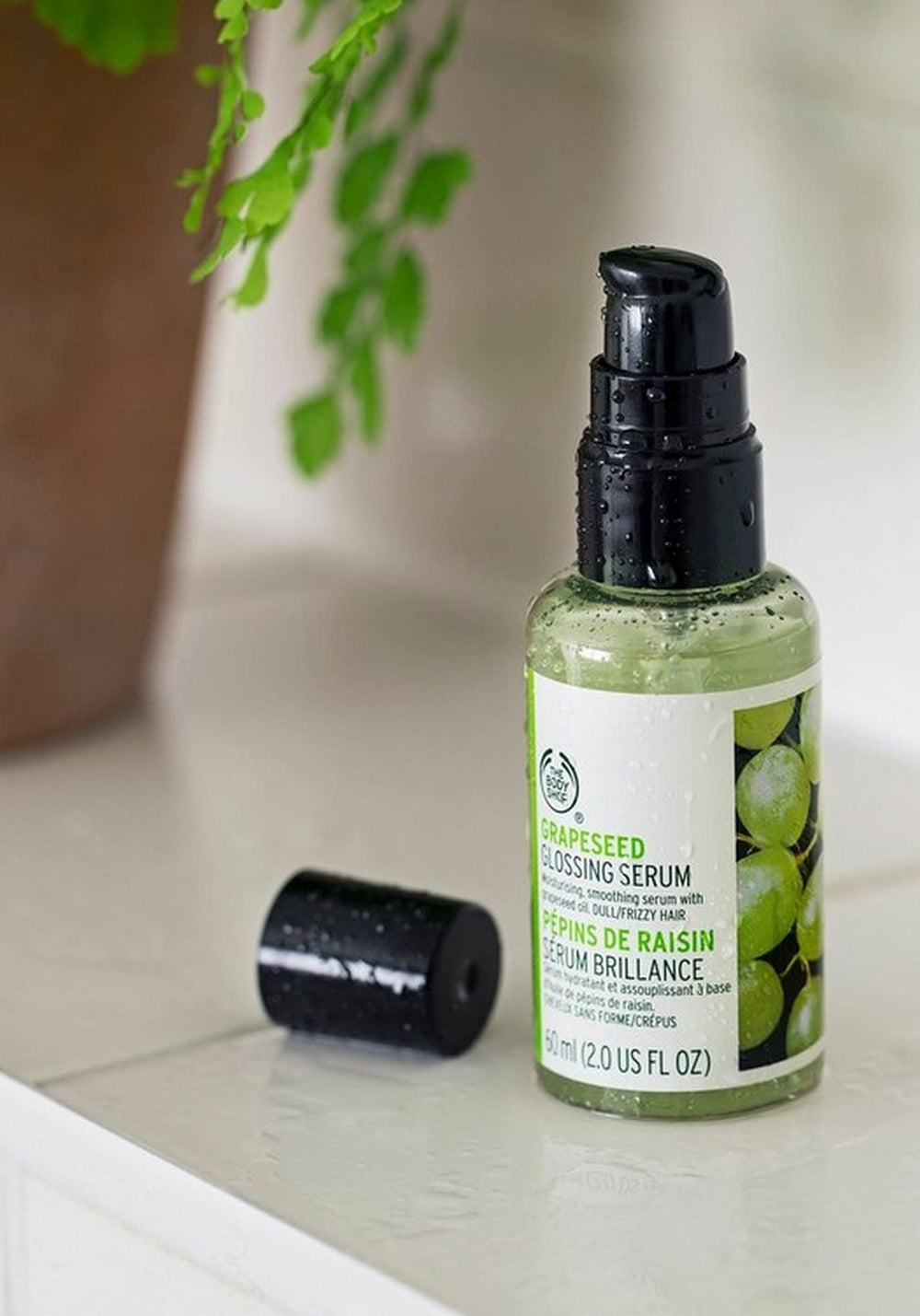 The Body Shop Grapeseed Glossing Serum being applied by hand for mid-length shine.