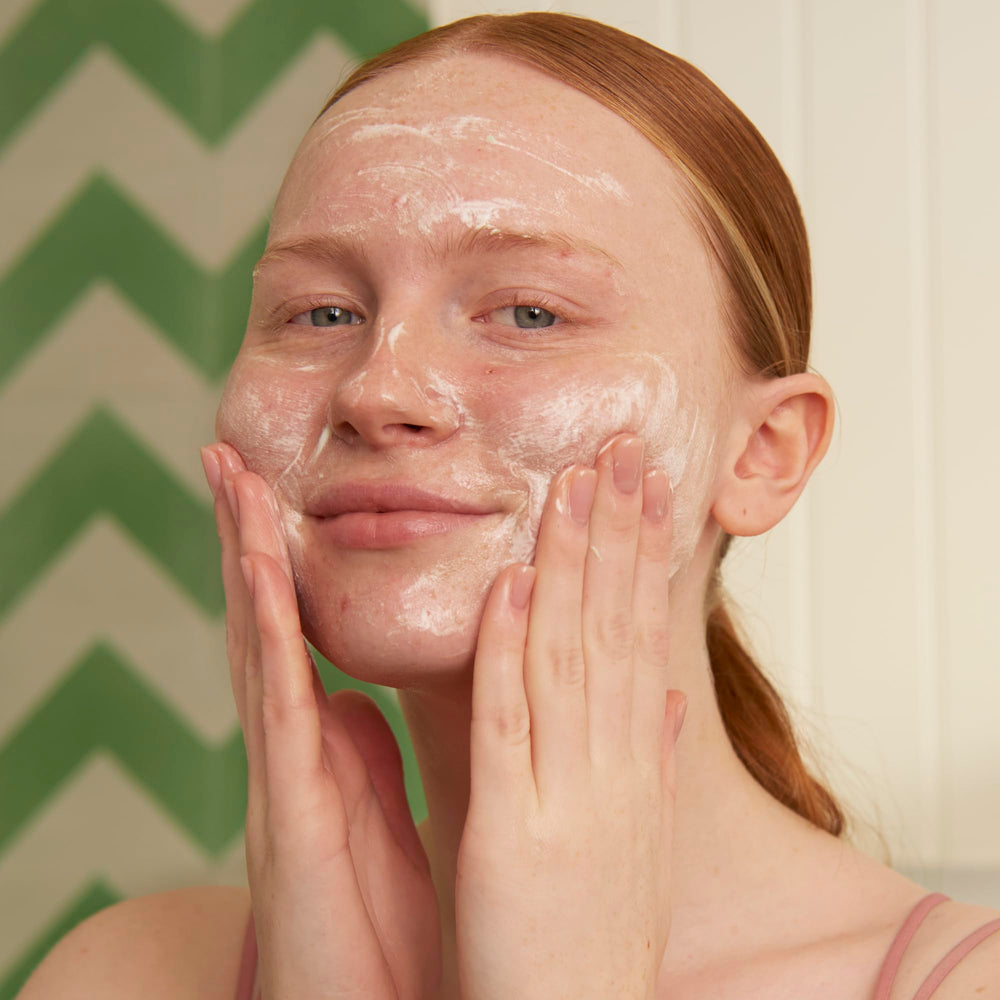 The Body Shop Tea Tree foaming cleanser foam close-up showing rich lather and clarifying action.