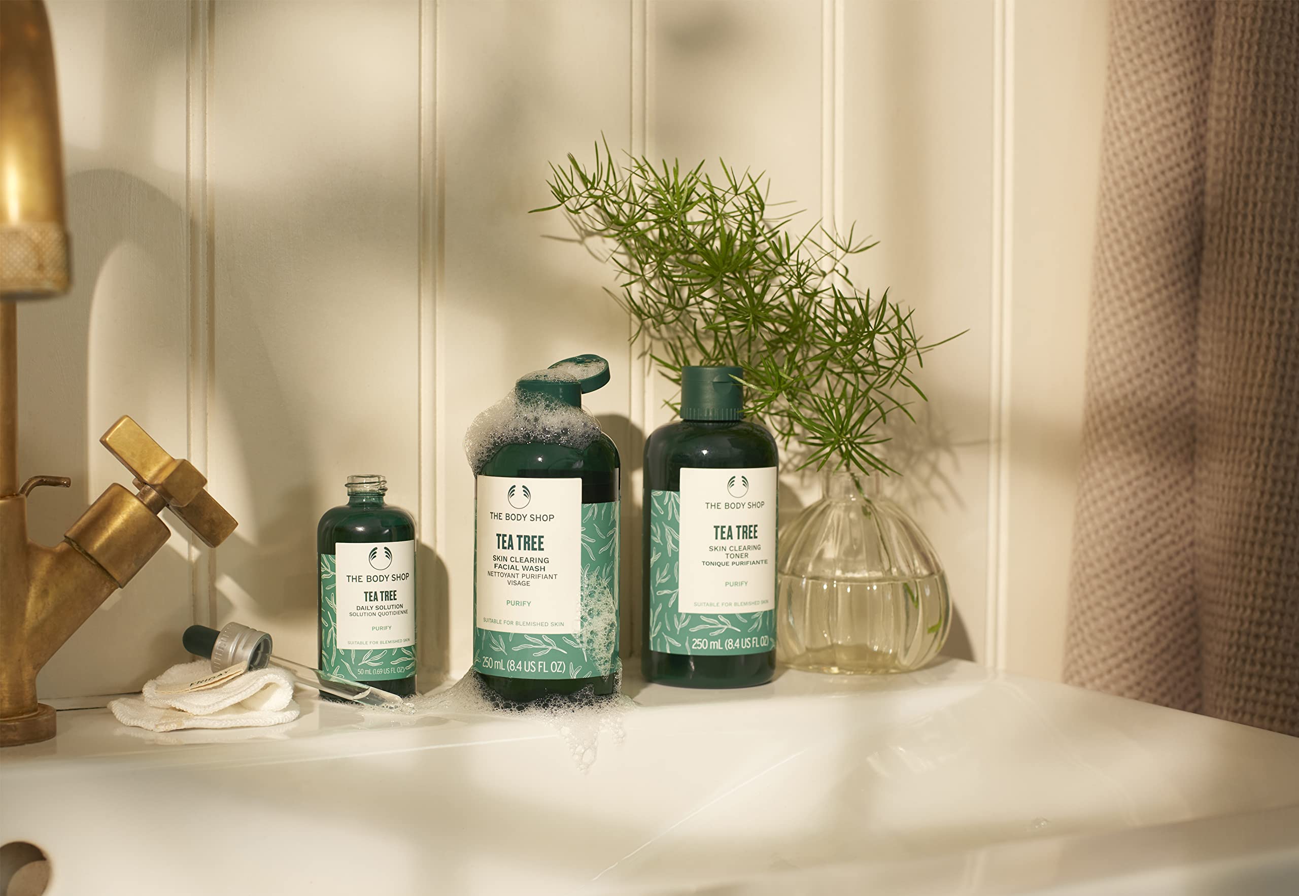 The Body Shop Tea Tree Toner packaging on shelf highlighting vegan and fair trade oil