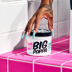 The Doux Big Poppa being applied to hair demonstrates frizz taming and moisture-locking benefits.