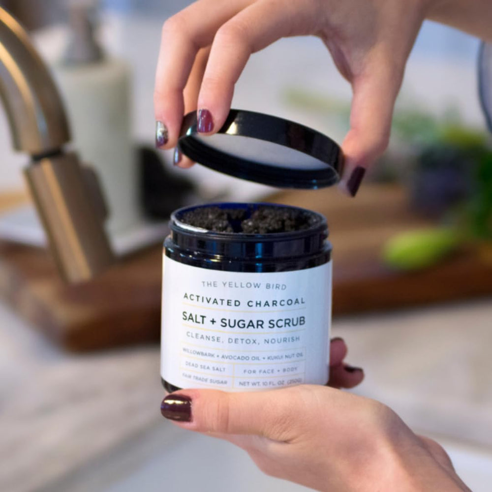 The Yellow Bird activated charcoal scrub full-body exfoliation shot shows versatile use.