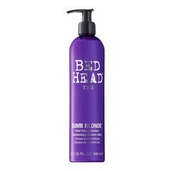 TIGI Bed Head Dumb Blonde purple-toning shampoo bottle neutralizes brass for cooler blonde tones.