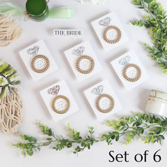 TOROS gold hair tie closeup on card highlights quality and gift-ready presentation.