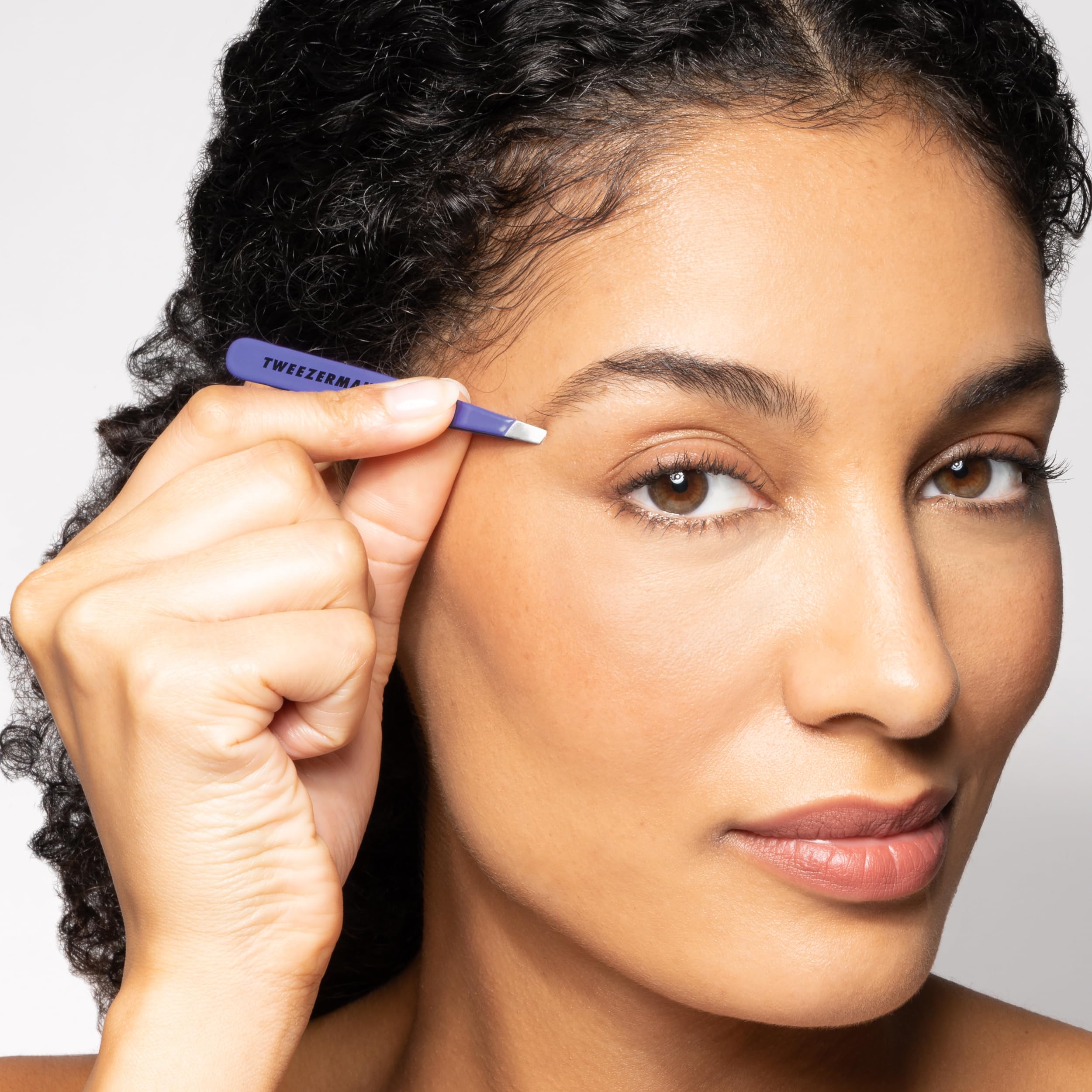 Tweezerman Mini Slant Travel Tweezers in hand usage shows steady control for accurate hair removal