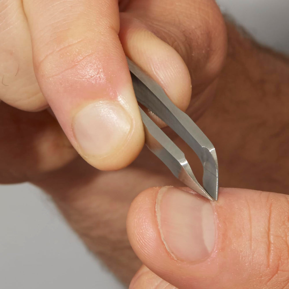 Tweezerman Mini Squeeze Cutical Nipper silver in-use action showing precise trimming.