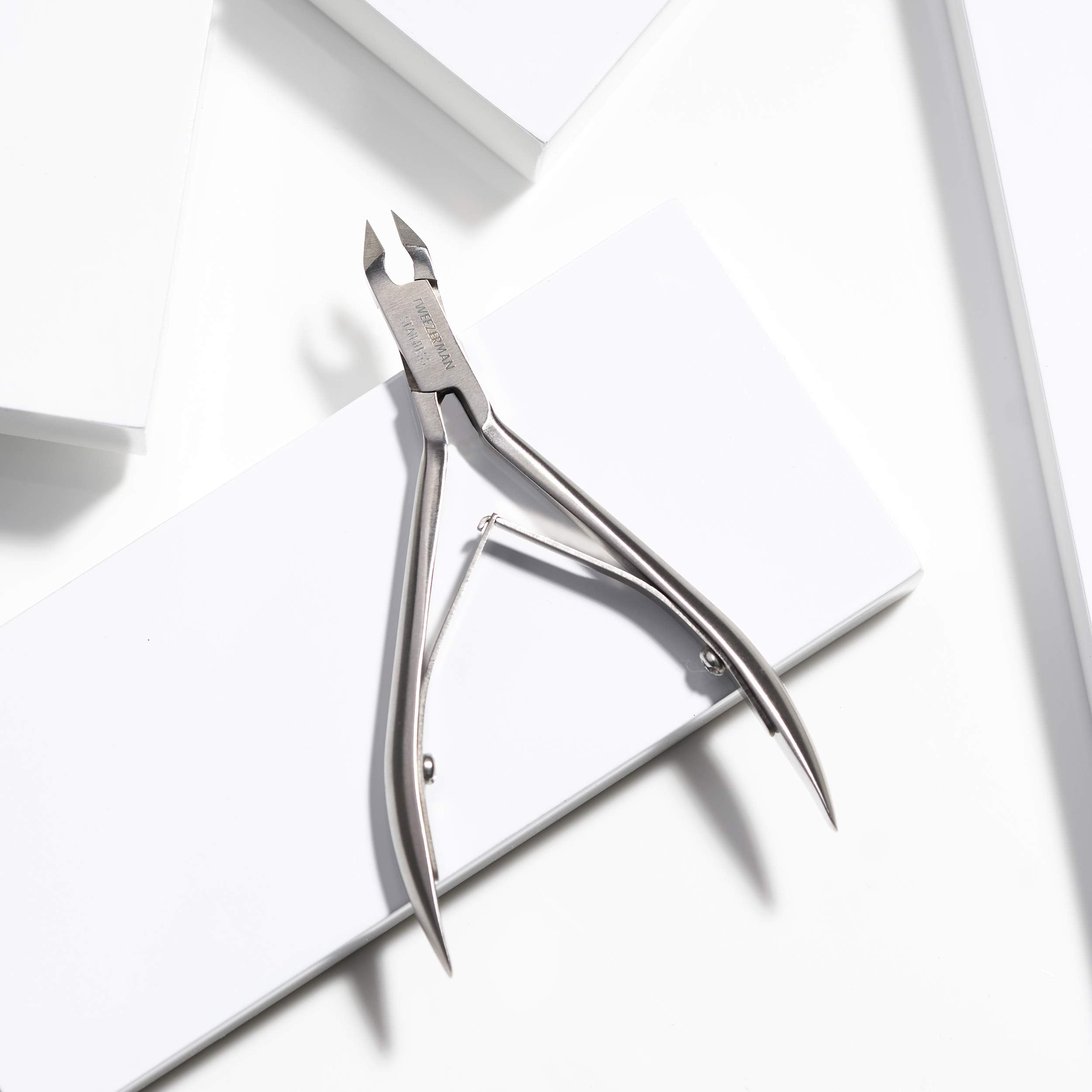 Tweezerman Rockhard Cuticle Nipper cleaning with alcohol wipe highlights sanitation-friendly maintenance.