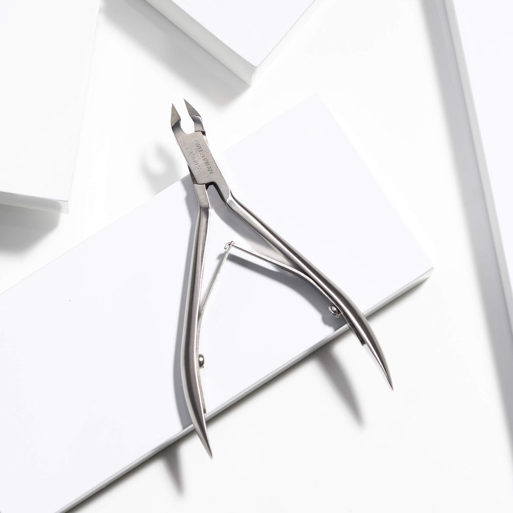 Tweezerman Rockhard Cuticle Nipper cleaning with alcohol wipe highlights sanitation-friendly maintenance.