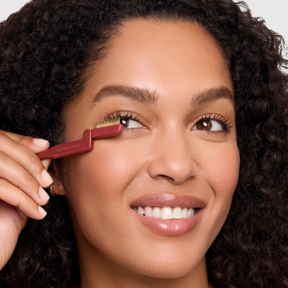 Tweezerman Vintage Rose Lash Curler in hand demonstrates smooth squeeze for wide-awake lashes.