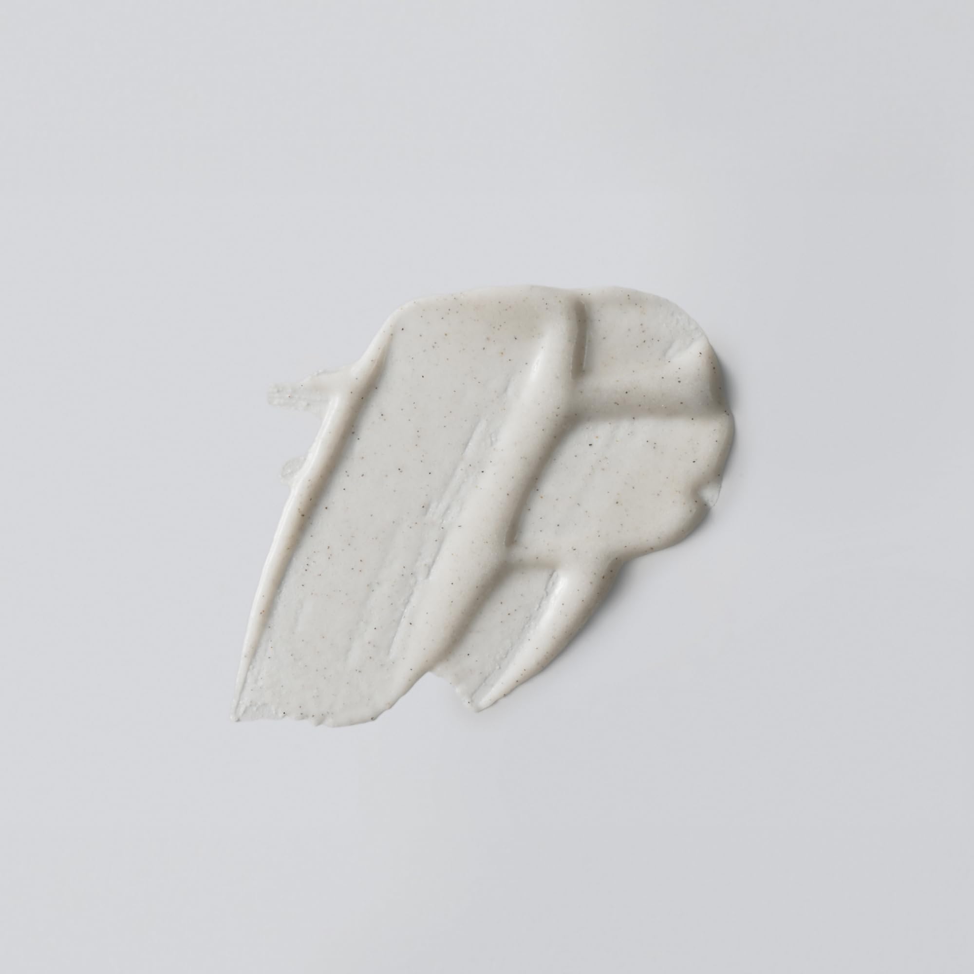 Versed Buff It Out in-shower application shows massaging action for exfoliating and softening skin.