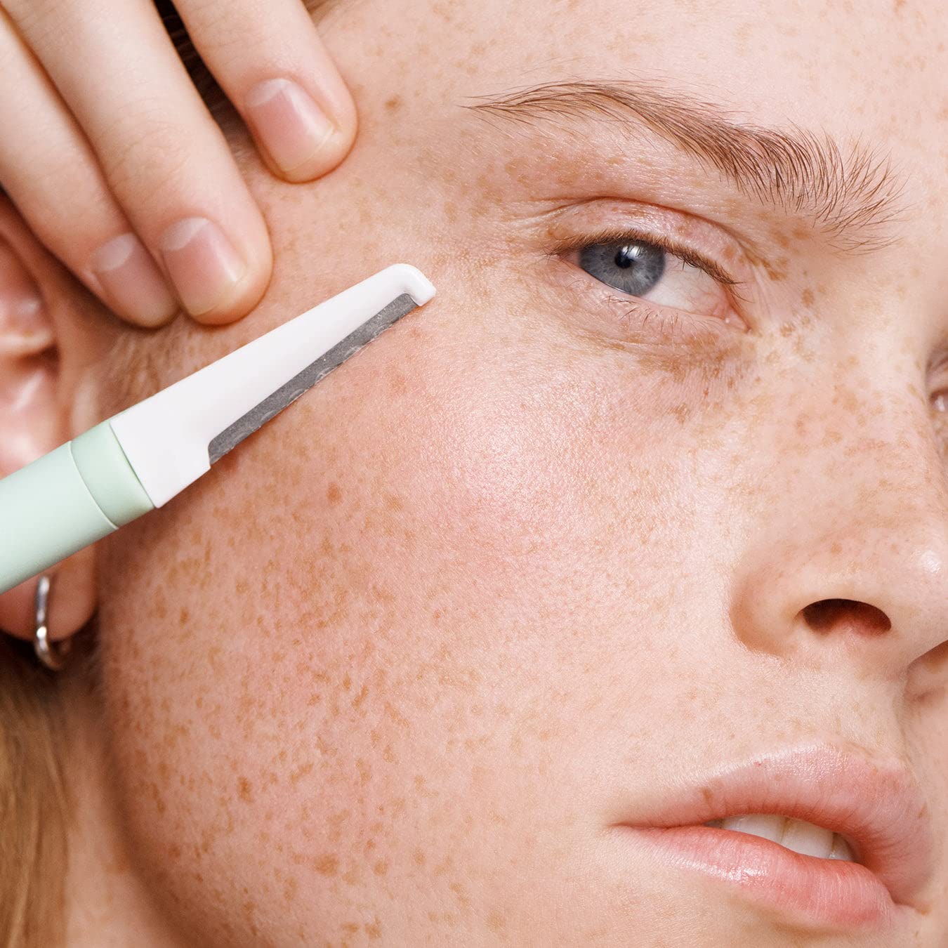 Versed dermaplaning tool in use on the cheek area for smoother skin.