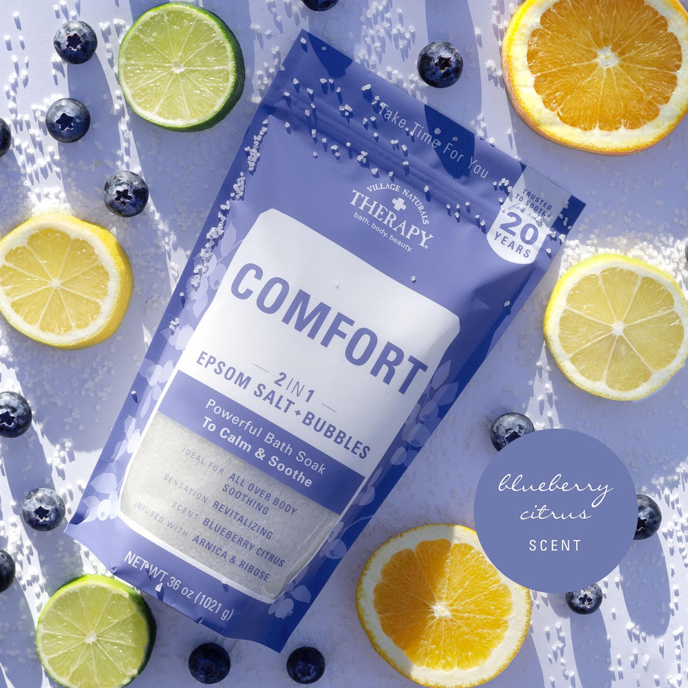 Village Naturals Therapy Comfort Foaming Bath Soak bubbles scene emphasizes spa-like relaxation after long day.