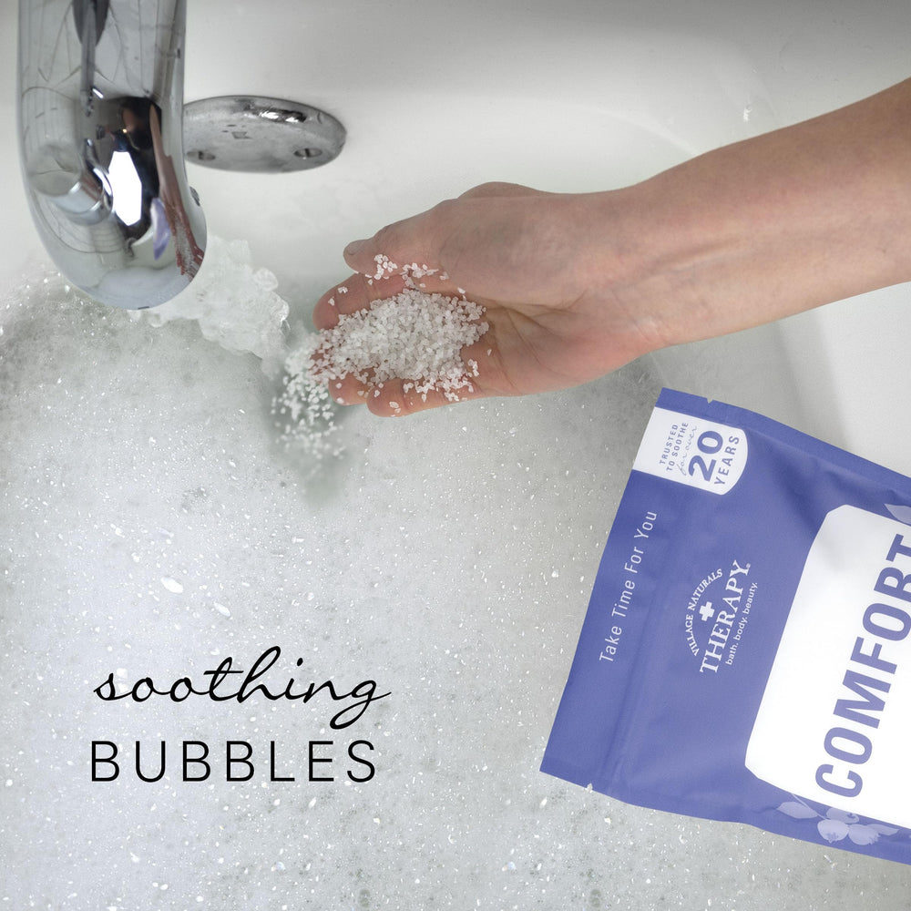Village Naturals Therapy Comfort Foaming Bath Soak ingredients closeup underlines arnica blueberry and flaxseed benefits.