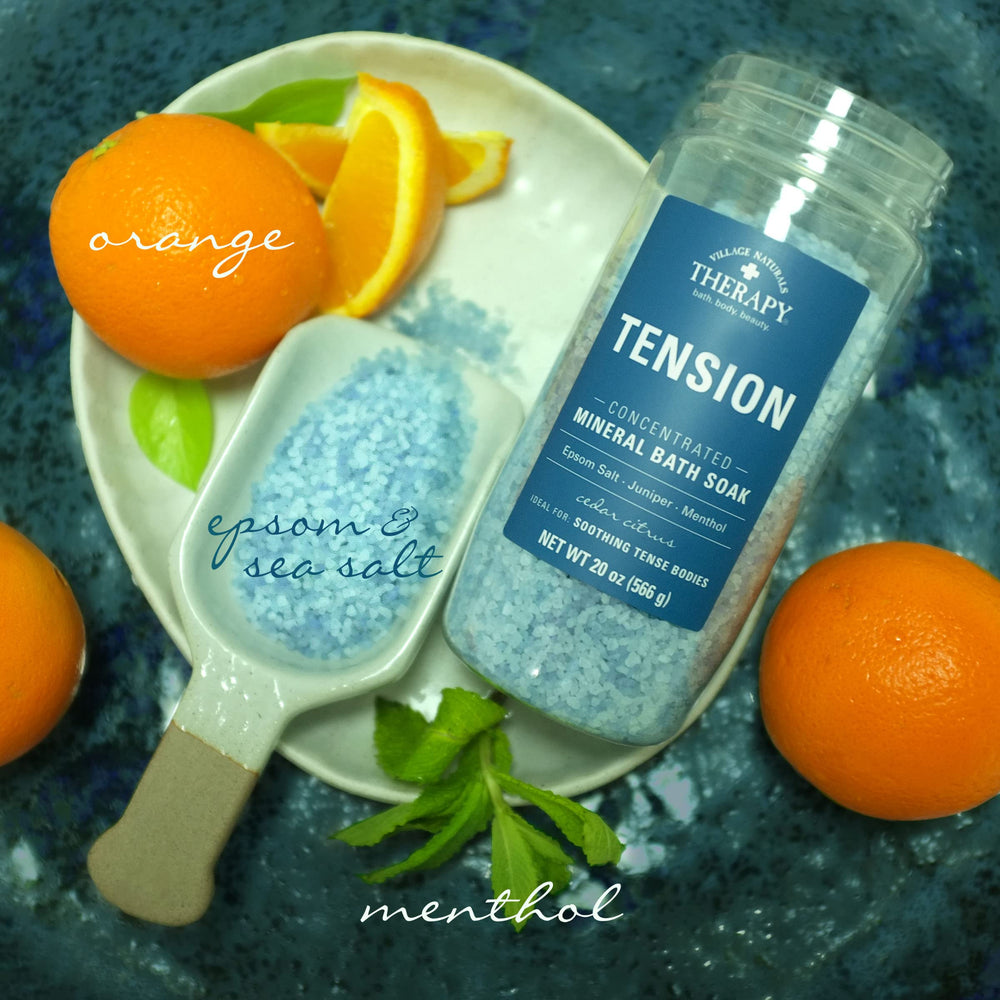 Village Naturals Therapy Tension Bath Soak Epsom salt crystals dispersing in bath water