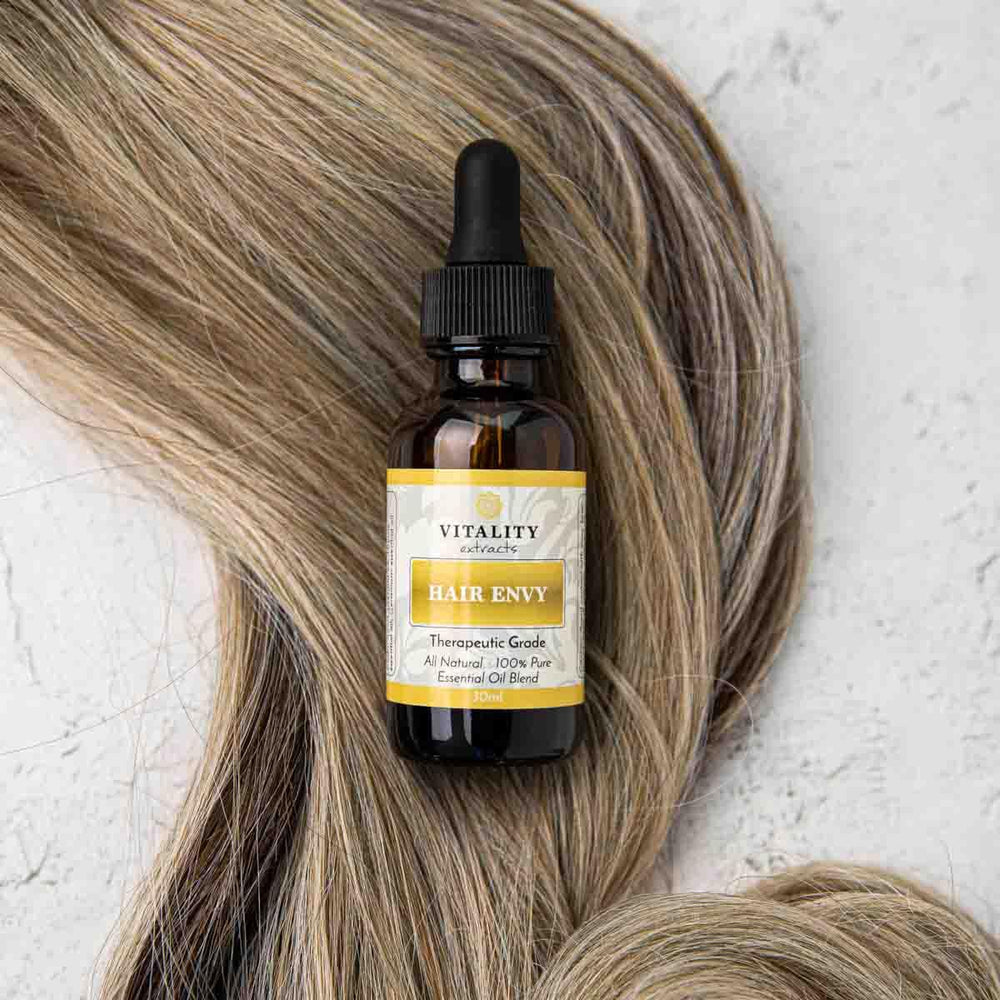 Vitality Extracts Hair Envy argan oil droplets on hair strand for smooth appearance