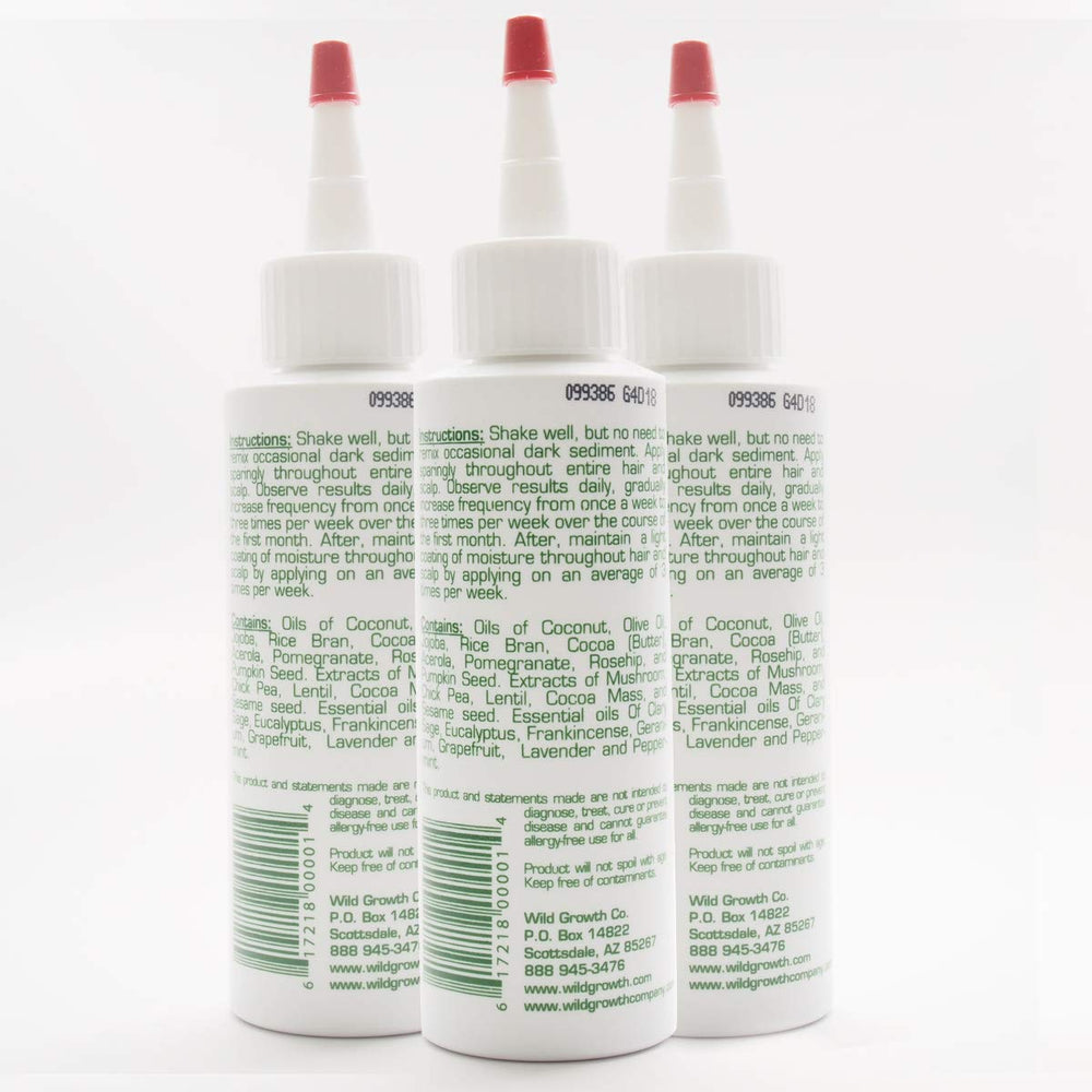Wild Growth hair oil application close-up shows multi-drop use for longer, softer hair.
