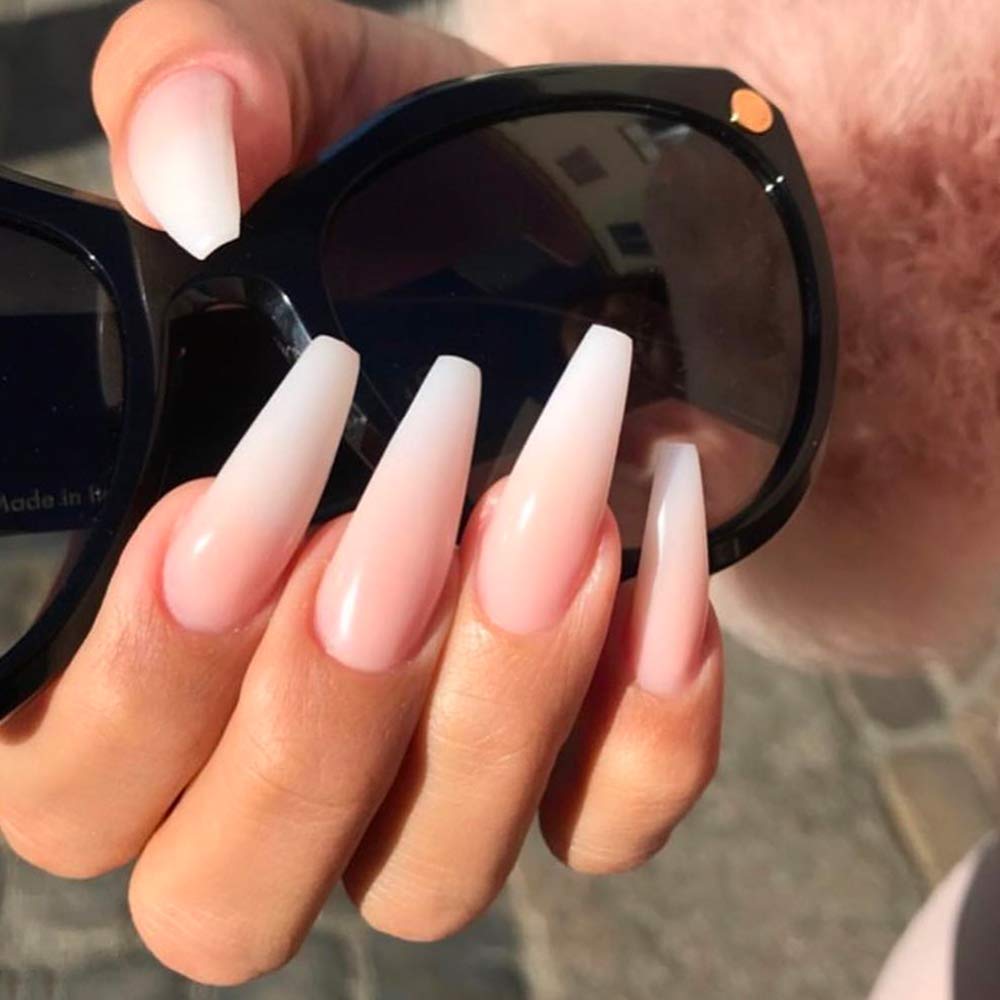 Young Nails finished manicure under lamp with top coat for long-lasting gloss.
